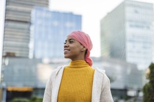 Une femme avec un foulard sourit et porte l'espoir sur son visage